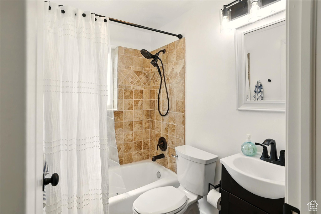 Full bathroom featuring shower / tub combo with curtain, vanity, and toilet