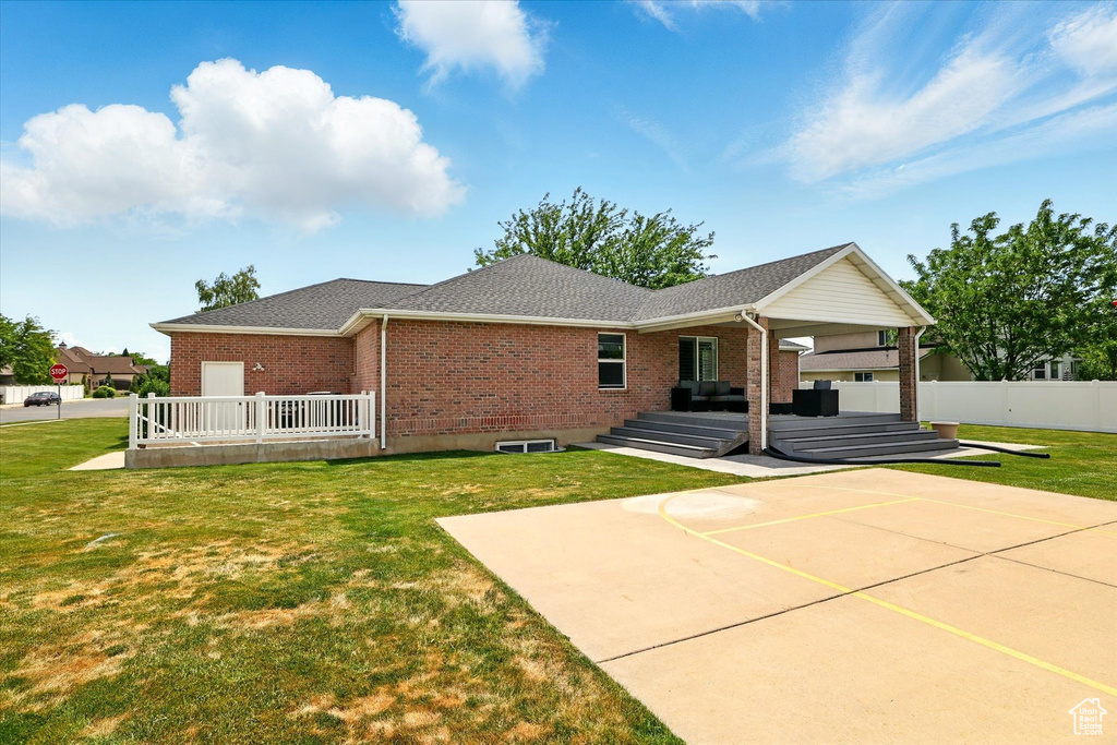 Rear view of property with a patio, brick siding, a deck, and roof with shingles