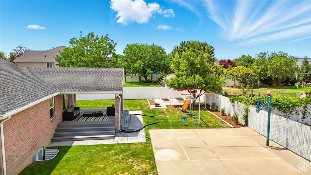 View of yard with a deck, a playground, and a patio