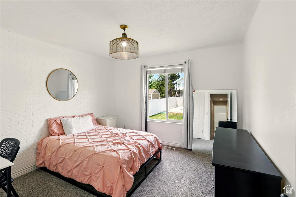 Carpeted bedroom with brick wall