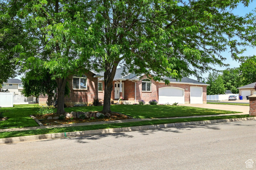 Ranch-style home featuring concrete driveway, brick siding, and a garage