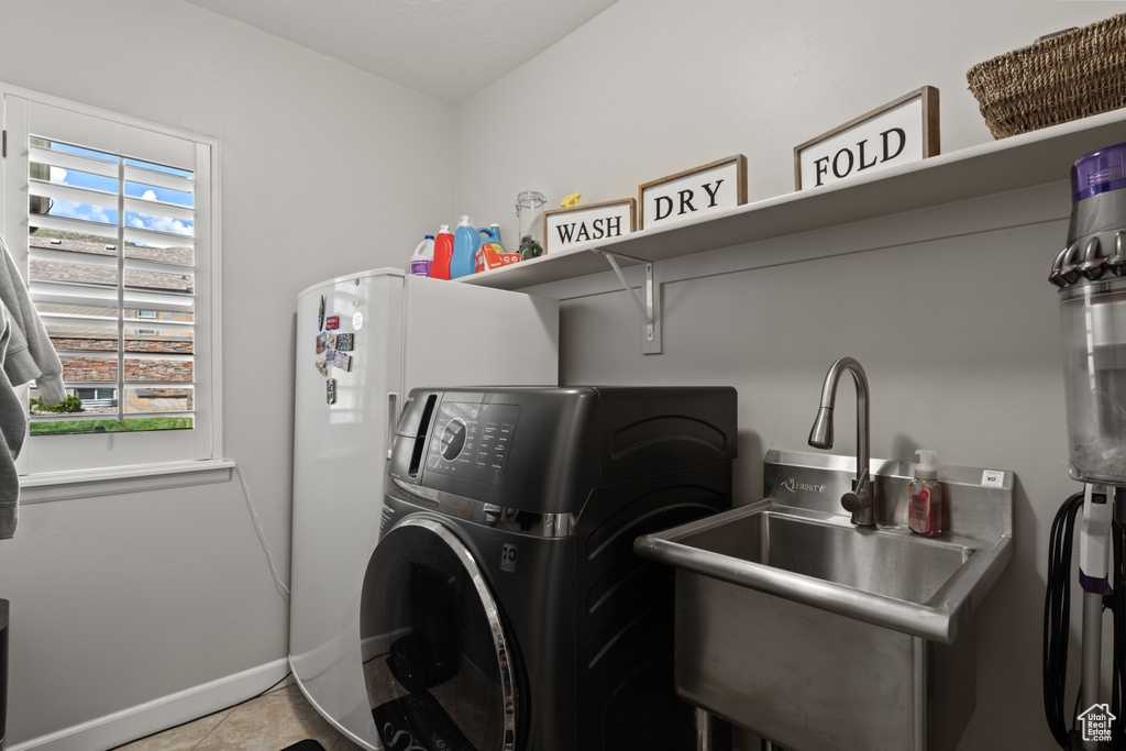 Laundry room with washer / clothes dryer, tile patterned flooring, and baseboards