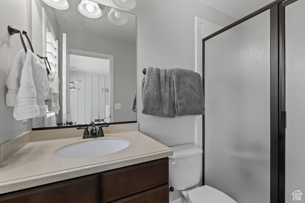 Bathroom with toilet, a shower stall, and vanity