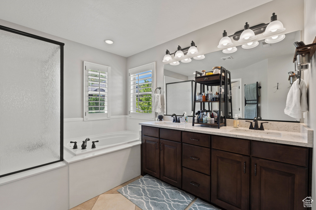 Full bathroom with a stall shower, a garden tub, double vanity, and tile patterned flooring