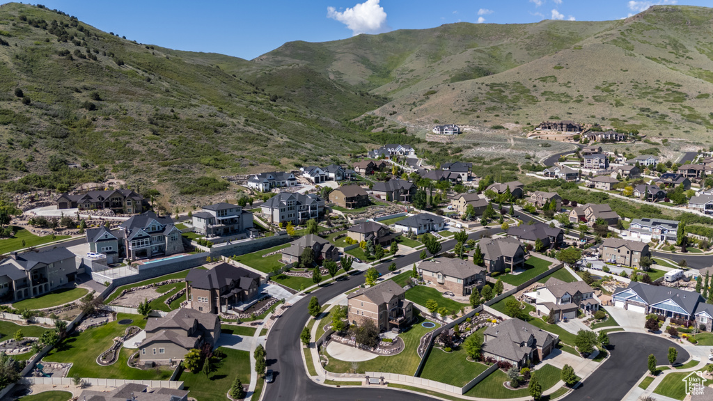 Aerial view of property and surrounding area featuring nearby suburban area and mountains
