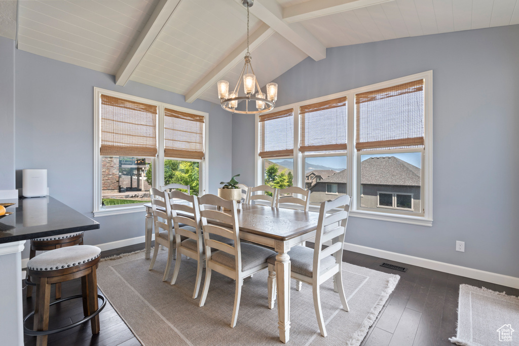 Dining space with baseboards, a chandelier, and dark wood-style flooring