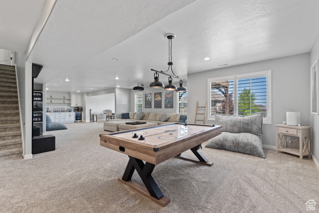 Recreation room featuring bar area, carpet flooring, recessed lighting, baseboards, and a textured ceiling