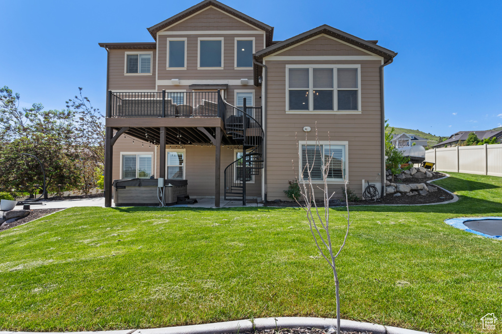 Rear view of house with a hot tub, stairs, a deck, and a patio area