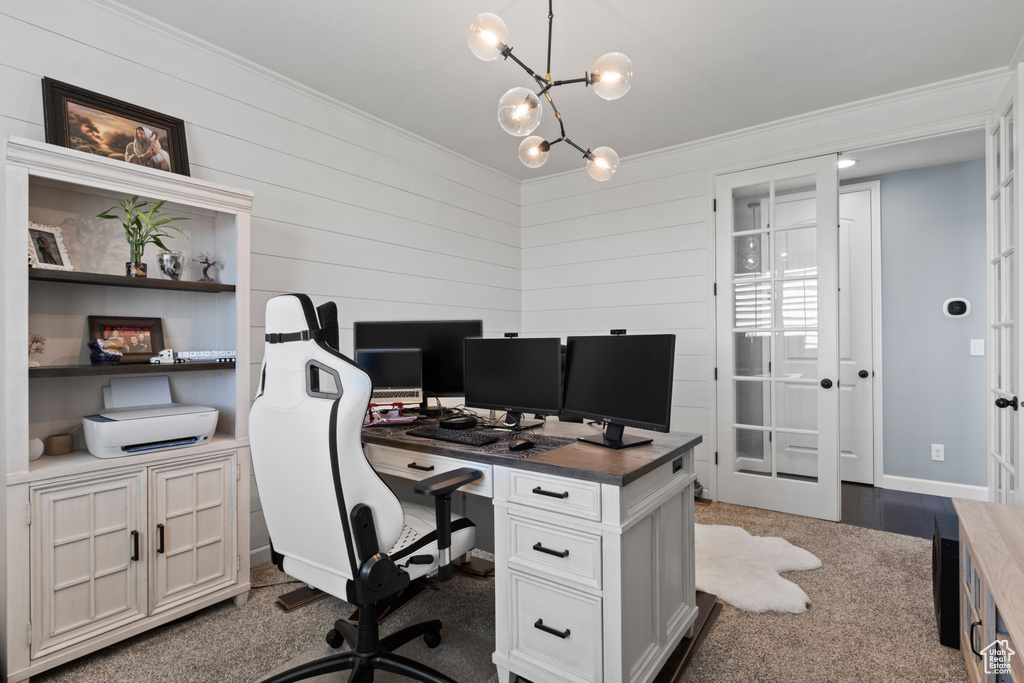 Office featuring ornamental molding, a chandelier, wooden walls, dark carpet, and french doors