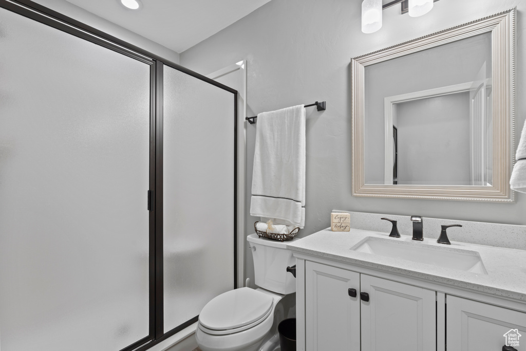 Full bath with vanity, a shower stall, and toilet