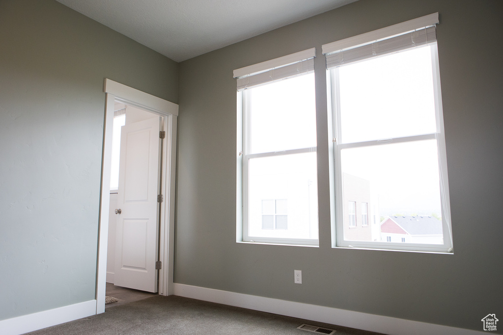 Unfurnished room featuring carpet and baseboards