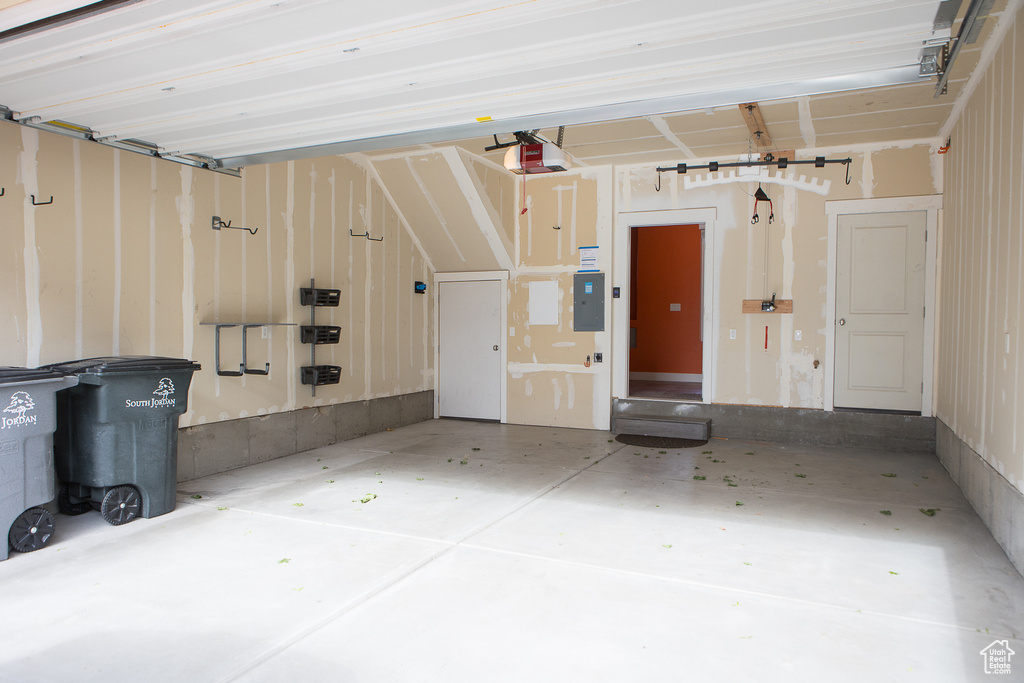 Garage featuring electric panel and a garage door opener