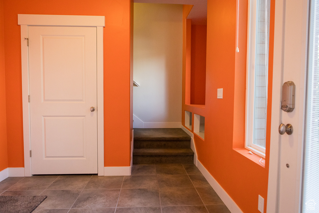 Stairway with baseboards and tile patterned floors