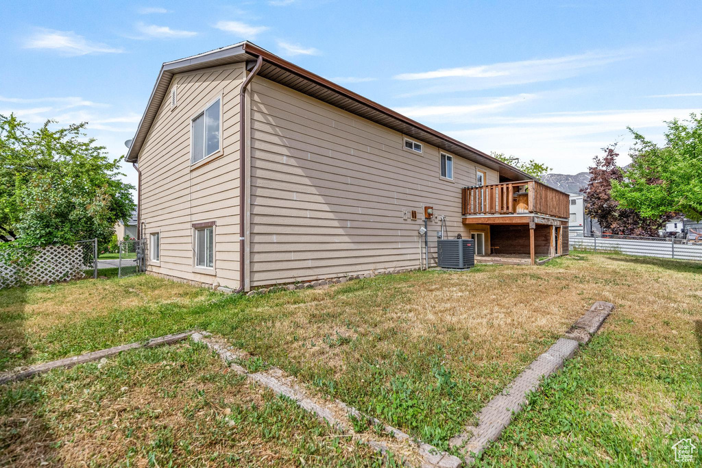Rear view of house featuring a deck and cooling unit