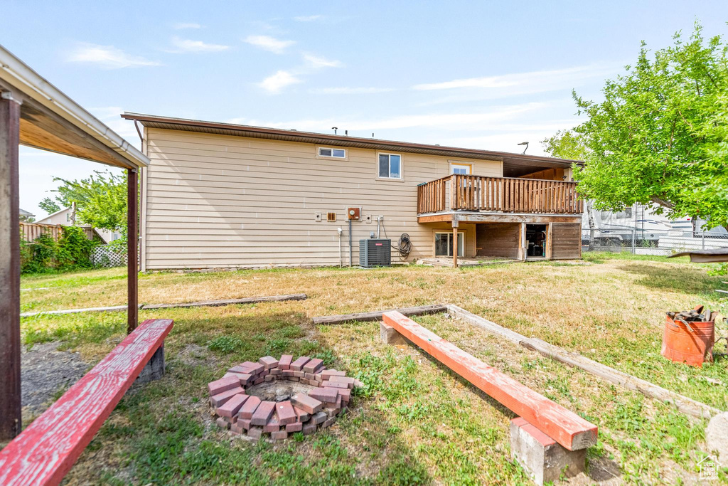 Back of house with a deck, central AC, and an outdoor fire pit