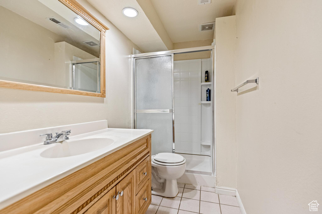 Bathroom featuring tile patterned flooring, vanity, toilet, a stall shower, and recessed lighting