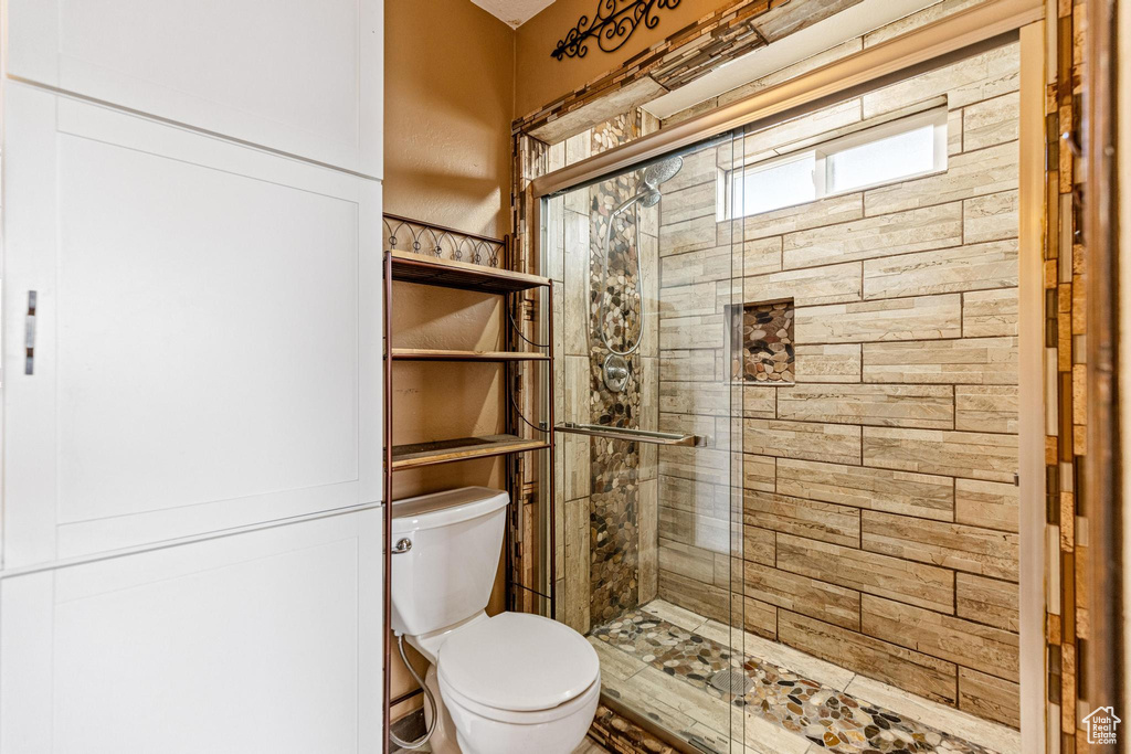 Bathroom with a shower stall and toilet