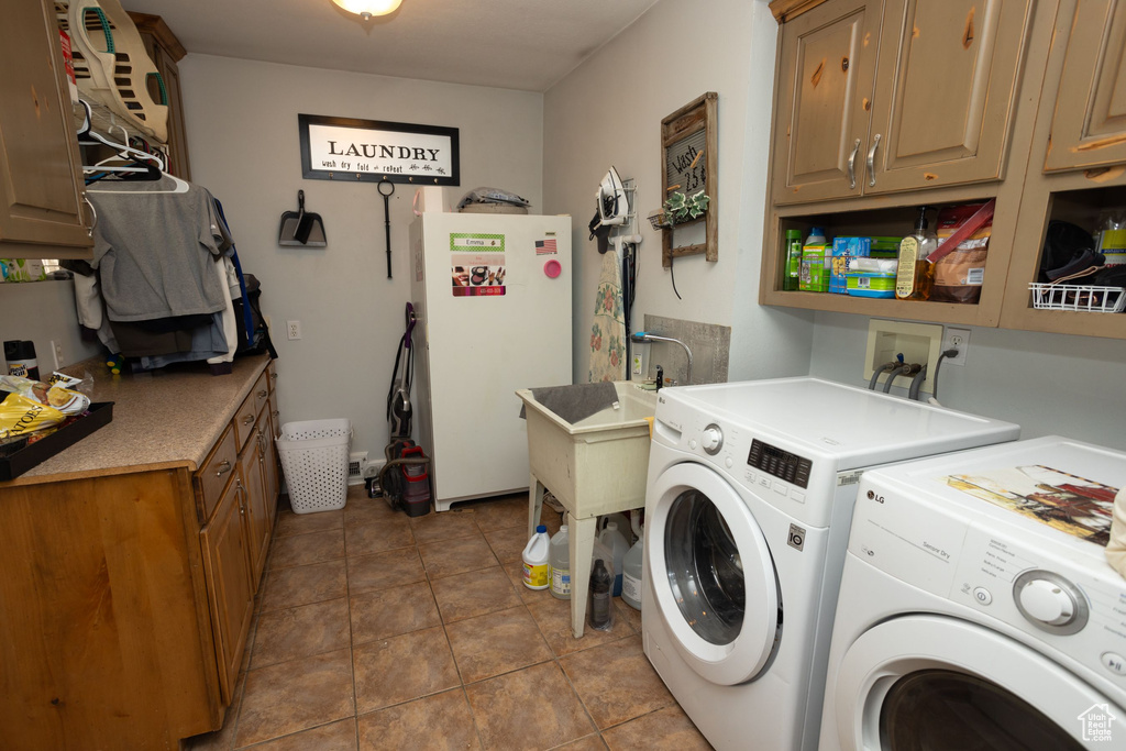Washroom featuring cabinet space, independent washer and dryer, and tile patterned flooring