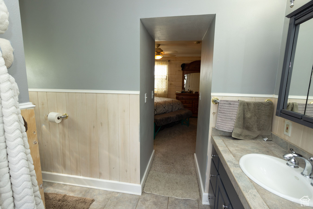 Bathroom featuring vanity, a ceiling fan, and a wainscoted wall