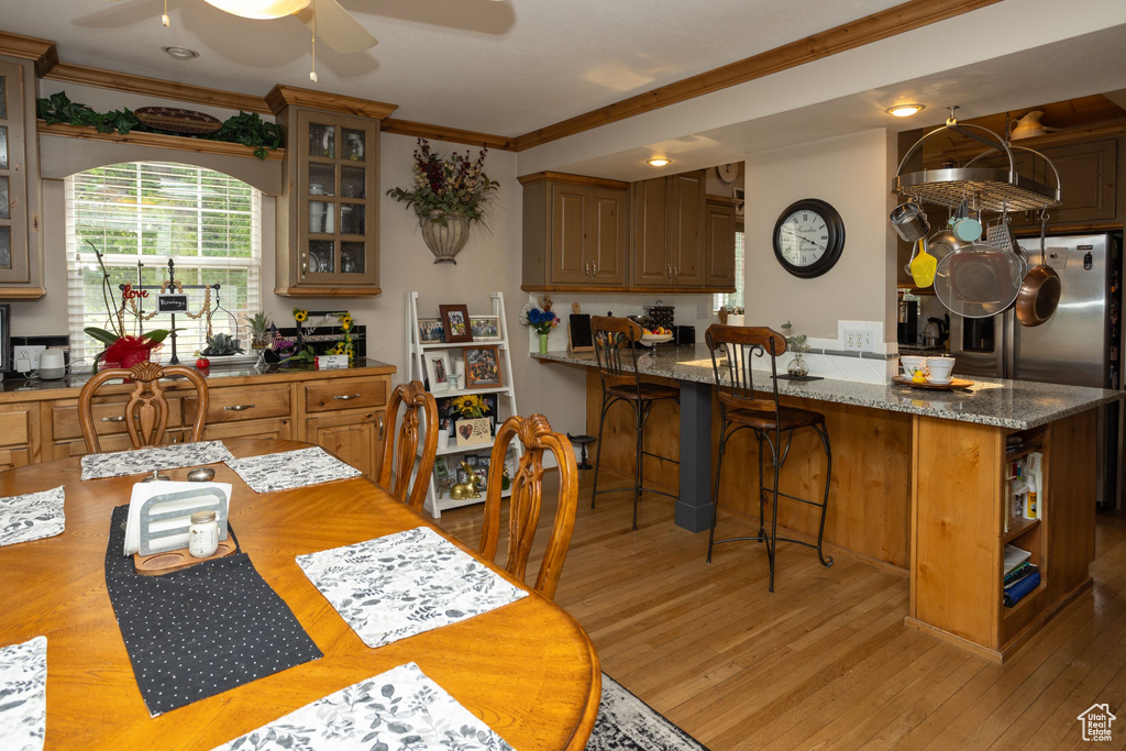 Dining room featuring crown molding, a ceiling fan, light wood-style floors, and recessed lighting