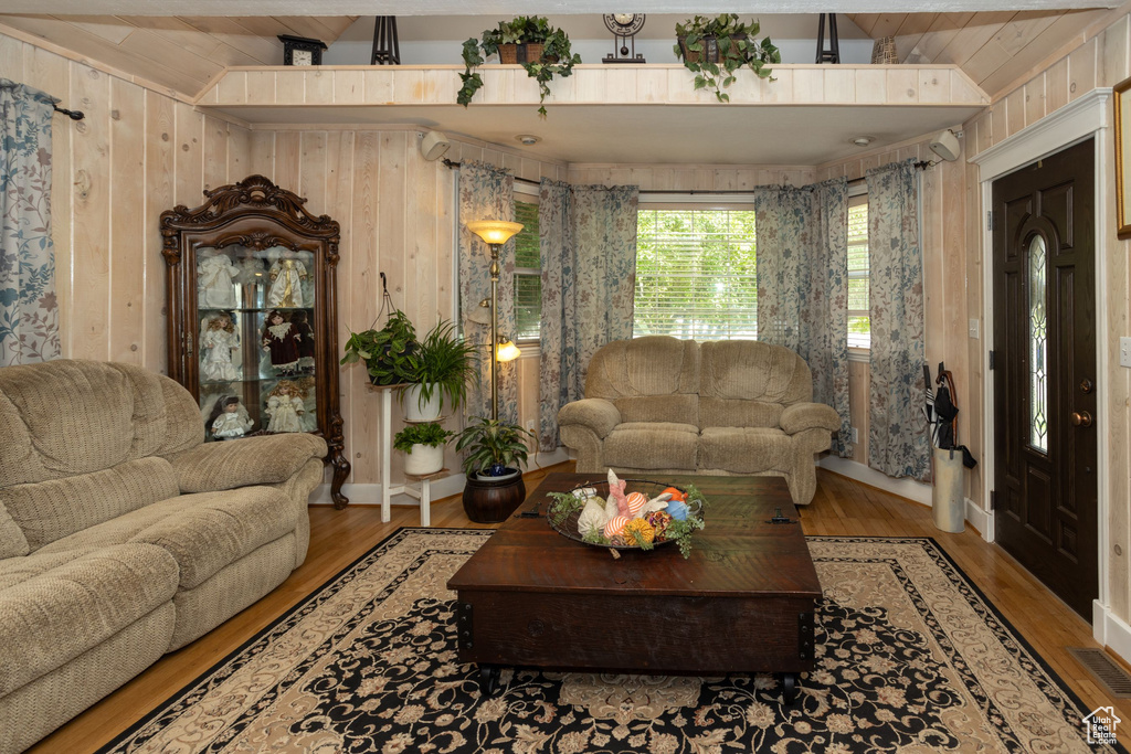Living room with wood finished floors, wood walls, and wooden ceiling