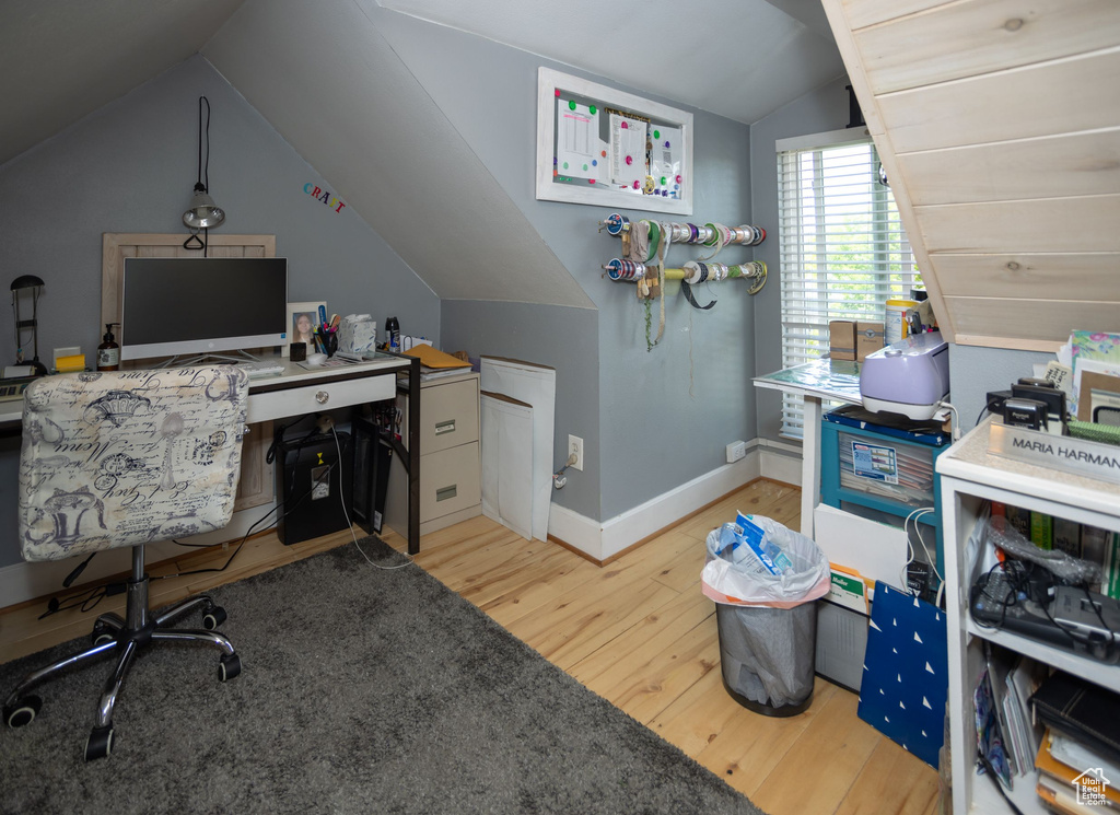 Home office featuring vaulted ceiling, wood finished floors, and baseboards