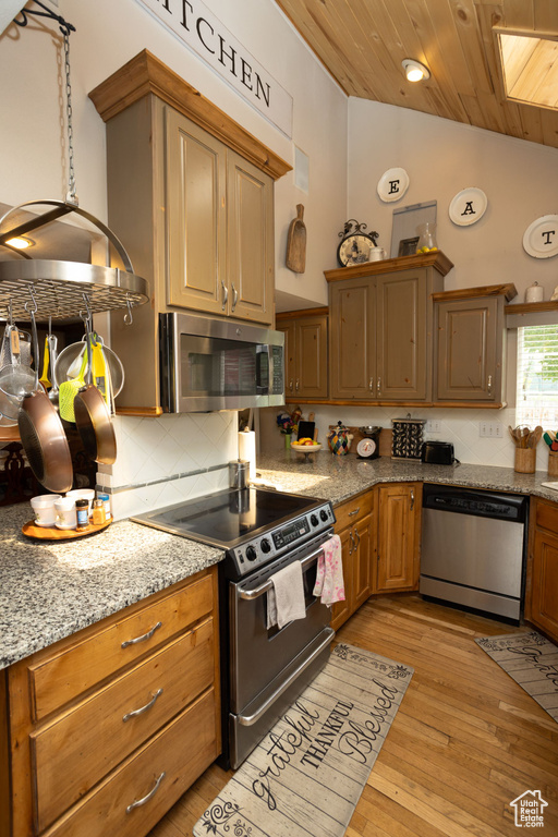 Kitchen featuring stainless steel appliances, tasteful backsplash, vaulted ceiling, wooden ceiling, and light wood finished floors