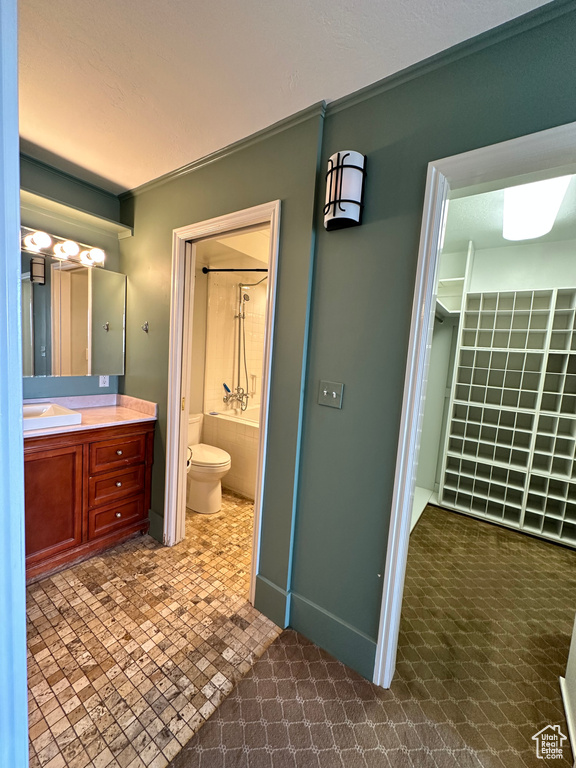 Bathroom with toilet, vanity, and baseboards