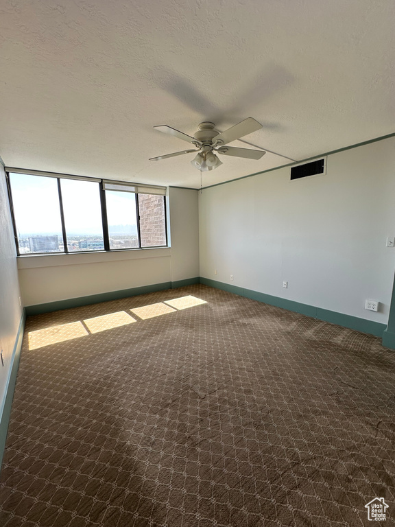 Carpeted empty room with ceiling fan and baseboards