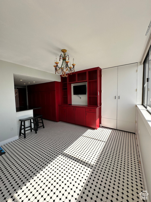 Unfurnished dining area with a chandelier and baseboards