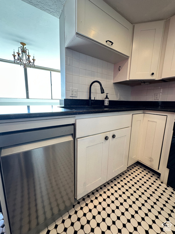 Kitchen featuring dishwasher, dark countertops, and tasteful backsplash