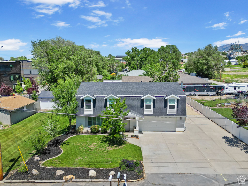 View of front of house with a shingled roof, driveway, and an attached garage