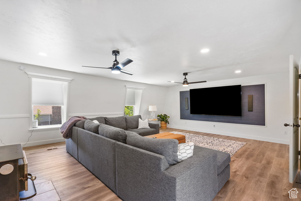 Living room with ceiling fan, light wood-style flooring, recessed lighting, and baseboards
