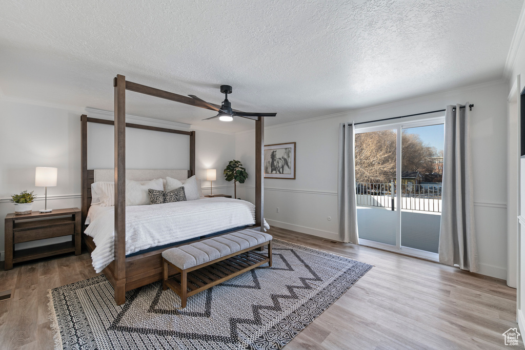 Bedroom featuring access to outside, ornamental molding, wood finished floors, a textured ceiling, and ceiling fan