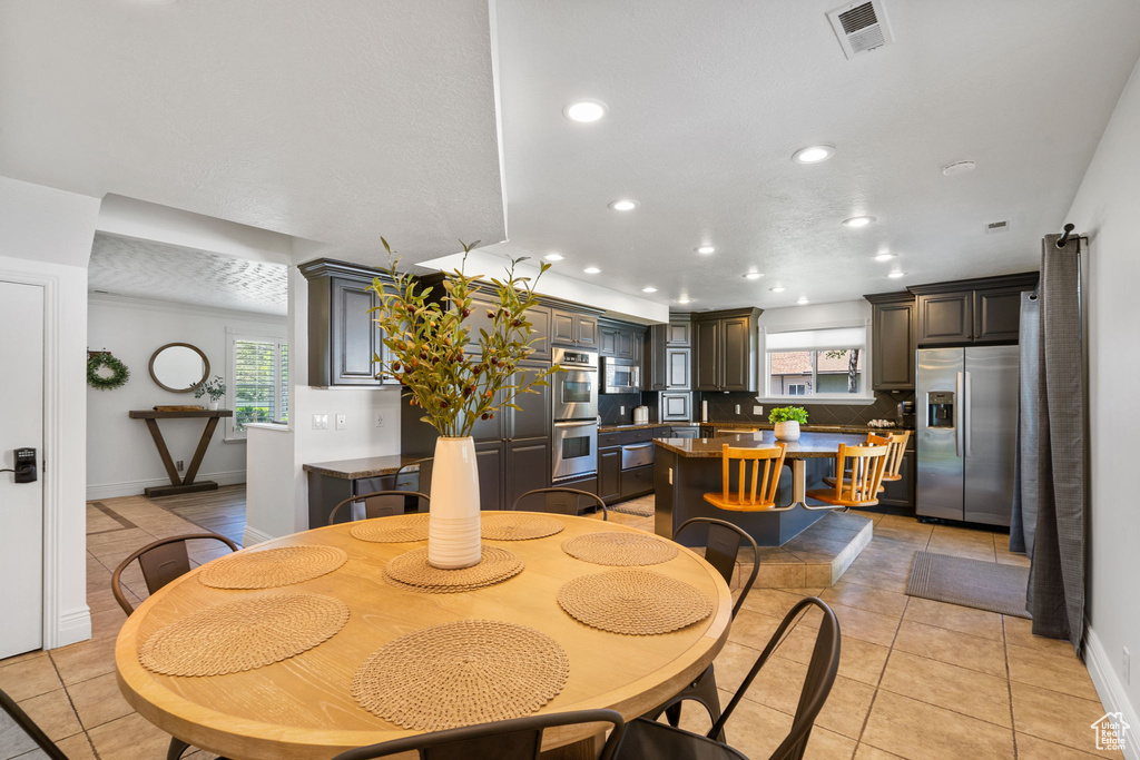 Dining room with recessed lighting, light tile patterned floors, plenty of natural light, and baseboards