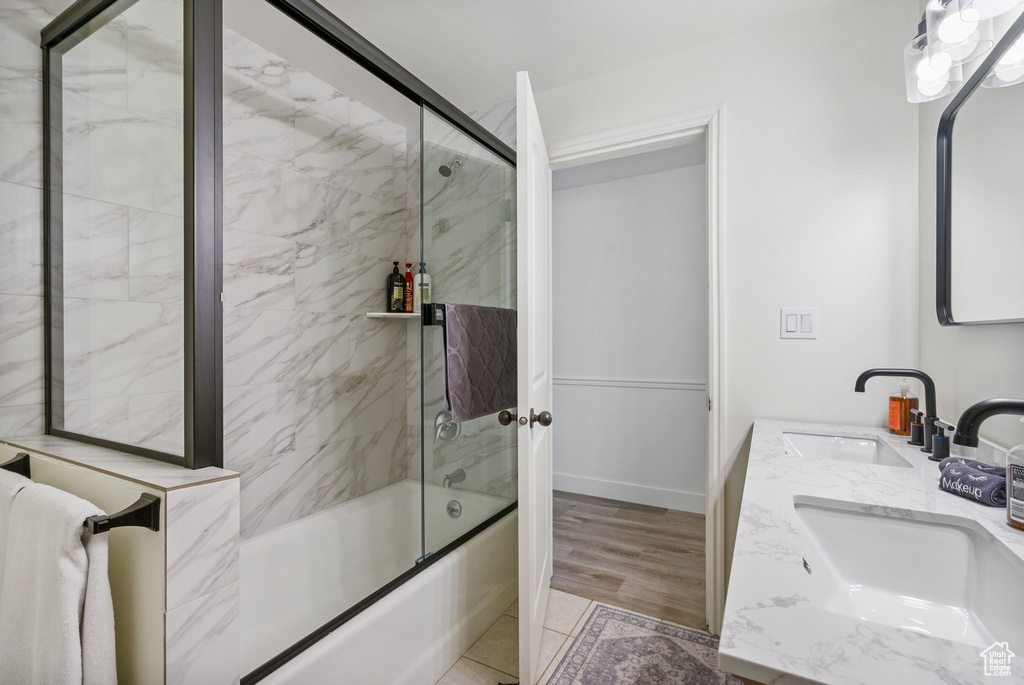 Bathroom with combined bath / shower with glass door and double vanity
