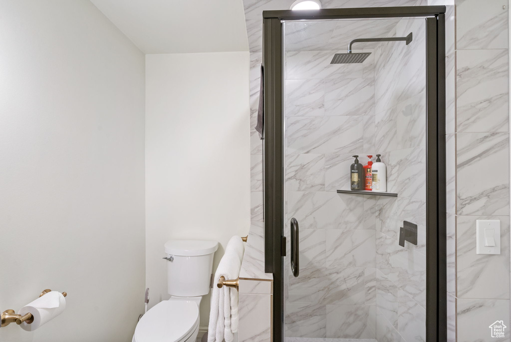 Bathroom featuring toilet and a shower stall
