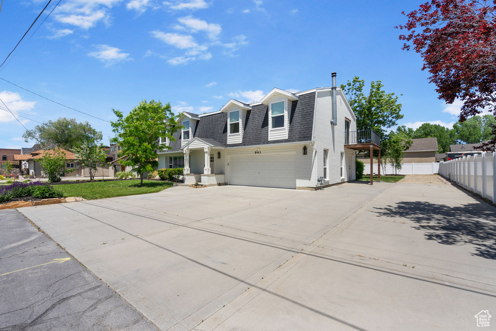 Dutch colonial featuring roof with shingles, a residential view, concrete driveway, and an attached garage