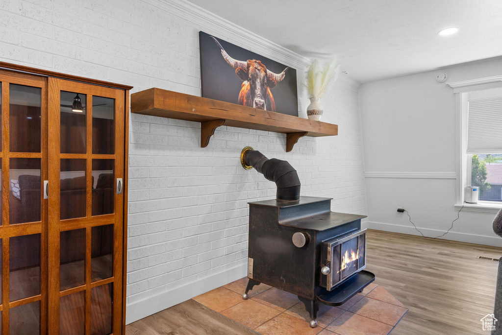 Detailed view of a wood stove, baseboards, wood finished floors, and recessed lighting