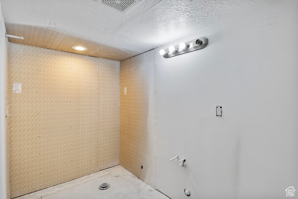 Interior space with unfinished concrete floors and a textured ceiling