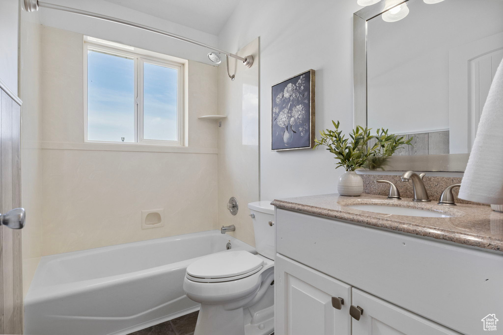 Bathroom featuring toilet, vanity, and tub / shower combination