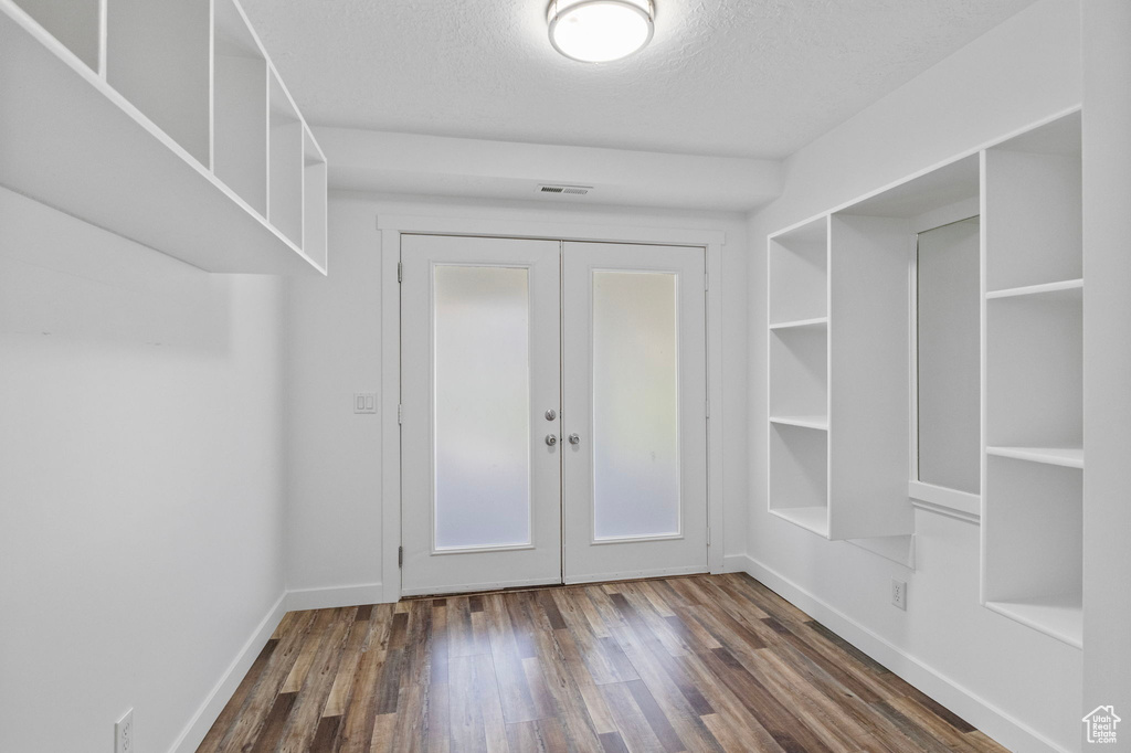 Mudroom with dark wood-style flooring, french doors, a textured ceiling, and baseboards