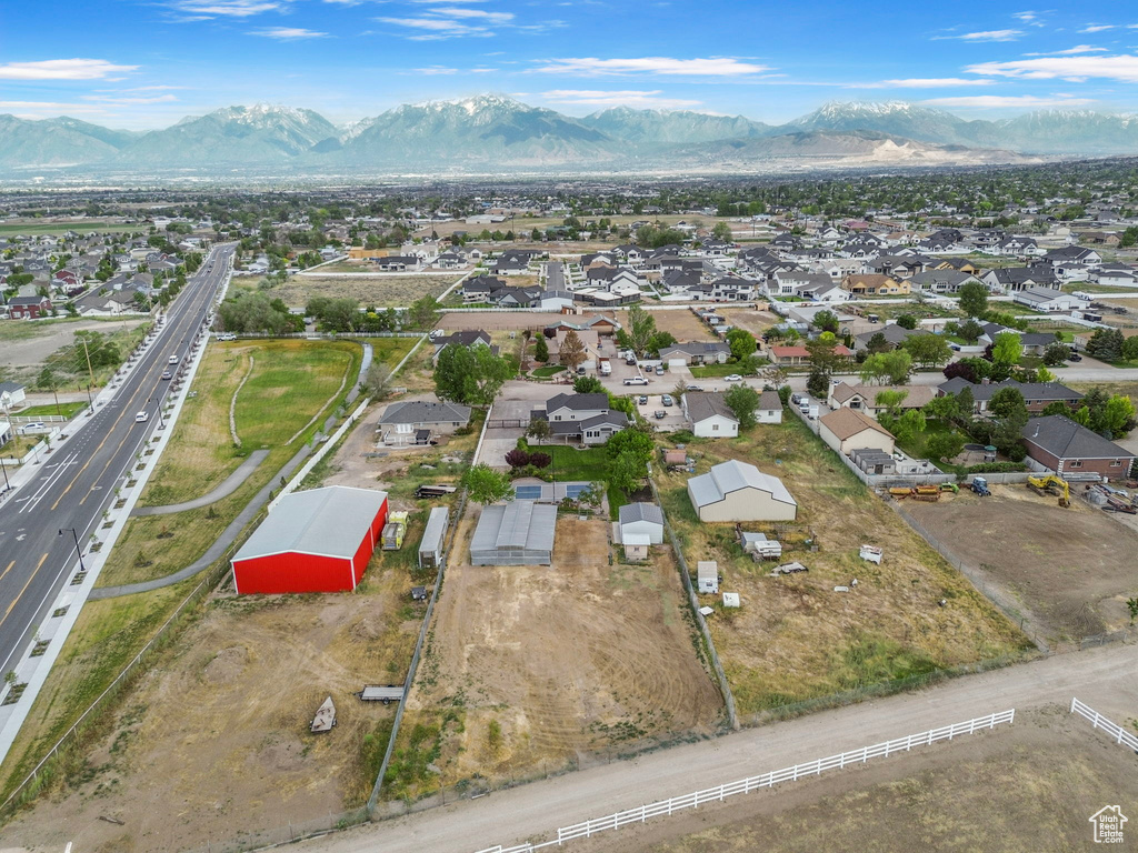 Aerial view of property and surrounding area featuring a major roadway, mountains, and nearby suburban area