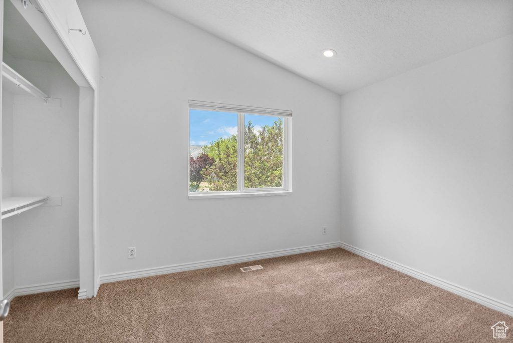 Unfurnished bedroom with carpet, vaulted ceiling, baseboards, a textured ceiling, and recessed lighting