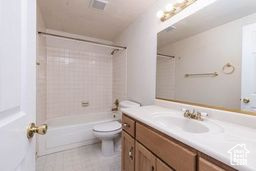 Full bathroom with vanity, toilet, shower / washtub combination, and tile patterned flooring