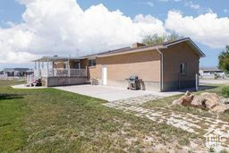 Rear view of house with a patio area and a lawn