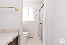 Full bathroom featuring vanity, a shower stall, and toilet