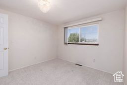 Carpeted empty room with baseboards