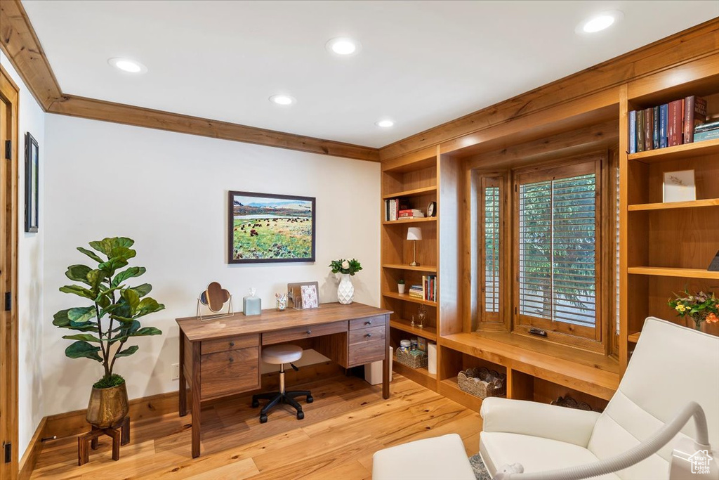 Office area featuring light wood finished floors, recessed lighting, and built in shelves