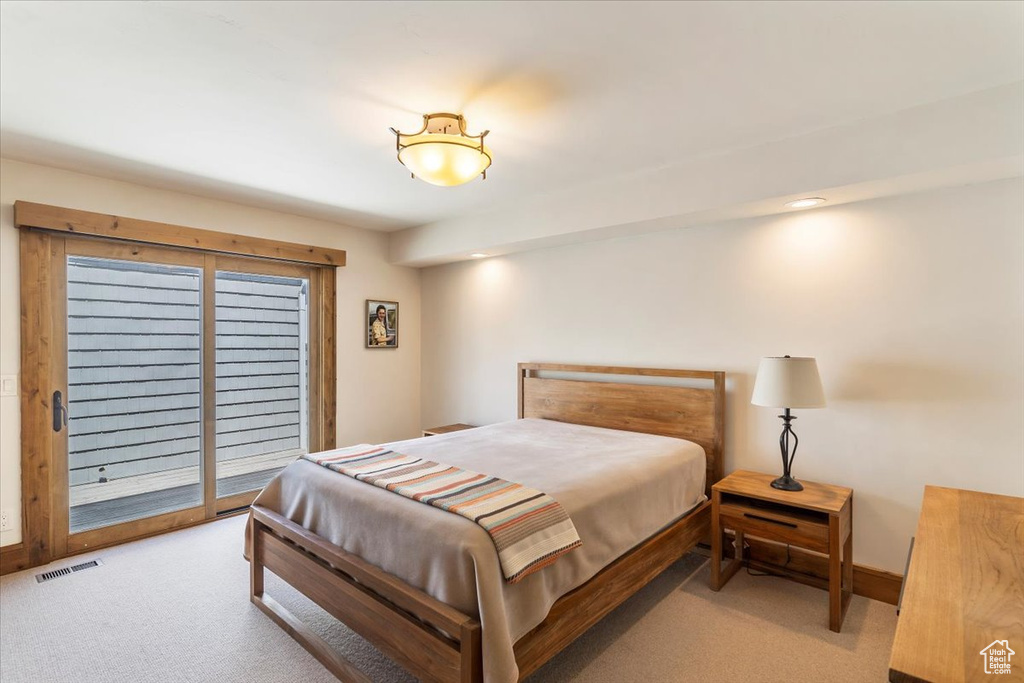 Bedroom with light carpet, access to exterior, and baseboards